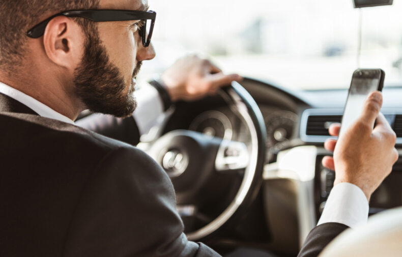 handsome driver in suit driving car and holding sm DMKMH8F scaled 1